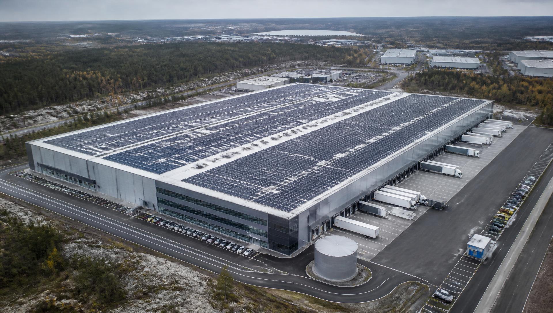 Flygbild över stor logistikfastighet med solcellsanläggning på taket